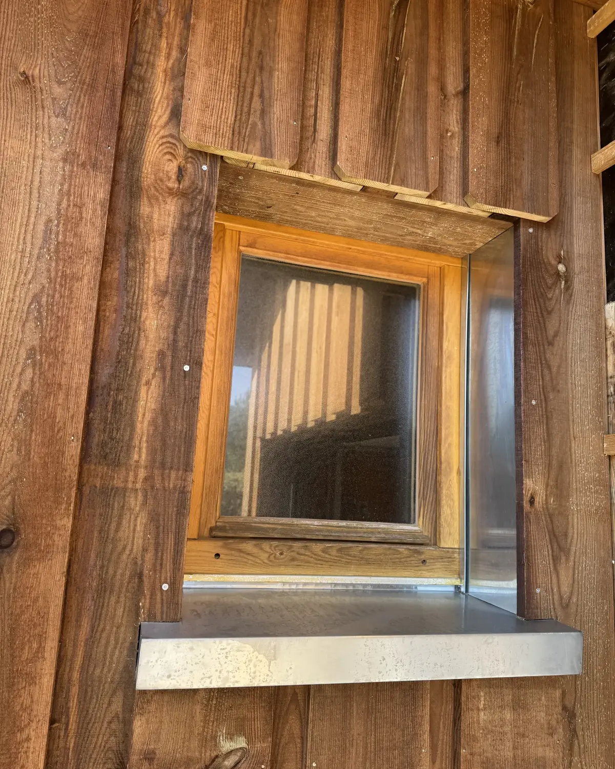 Appui de fenêtre et tableau en zinc dans un bardage bois